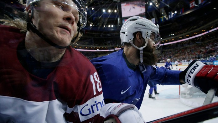 Francúzsky hráč Antonin Manavian (vpravo) naráža lotyšského hráča Rodriga Abolsa na plexisklo