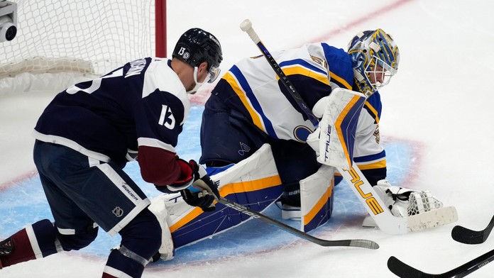 Brankár St. Louis Blues Jordan Binnington (vpravo) kryje puk po tom, čo zastavil strelu pravého krídla Colorada Avalanche Valeriho Nicushkina. 