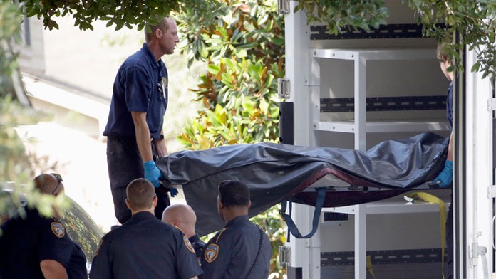 Policajti vynášajú mŕtvoly z domu v Texase.