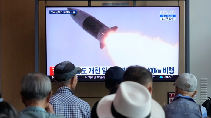 Na snímke ľudia, ktorí sa pozerajú na televíznu obrazovku a sledujú odpálenú raketu z KĽDR.
