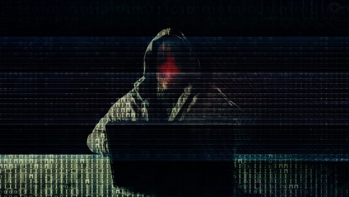 Na snímke hacker, ktorý sedí za počítačom.