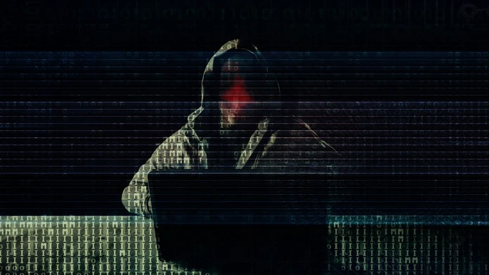 Na snímke hacker, ktorý sedí za počítačom.