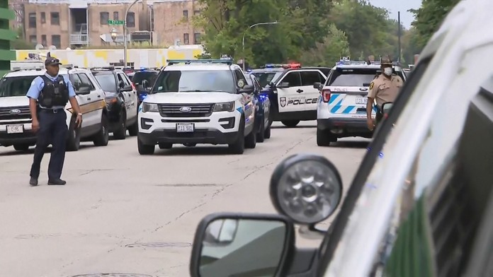 Čašník s ochranným rúškom a rukavicami kráča s podnosom na barovú terasu v Madride.