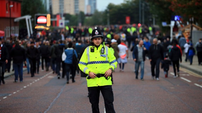Policajt sleduje príchod fanúšikov na štadión v zápase LM ManUtd - Bern.
