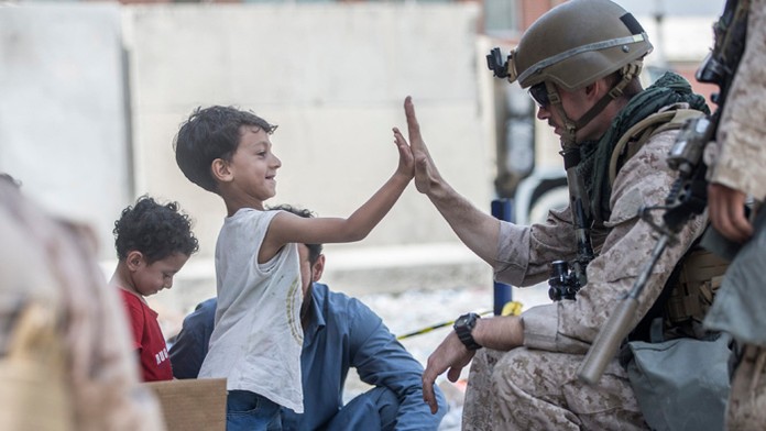 Americký vojak s afganským chlapcom počas evakuácie na letisku Hamída Karzaja v Kábule.
