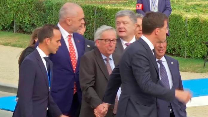 Holandský premiér Mark Rutte pomáha šéfovi EK Jean-Claude Junckerovi.