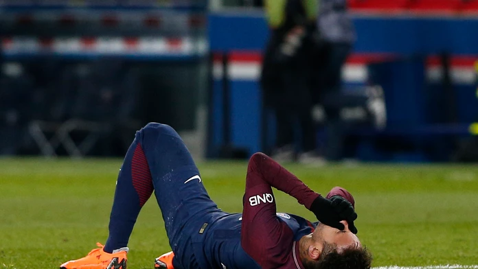 Hviezda PSG Neymar leží na trávniku po tom, čo sa zranil v ligovom zápase proti Marseille.
