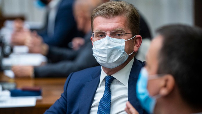 Ľudia držia fotografiu zosnulého učiteľa dejepisu a geografie Samuela Patyho počas spomienkového pochodu.