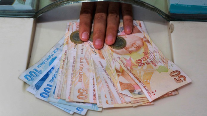 Pracovník zmenárne zamieňa zahraničnú menu za tureckú líru v zmenárni v Istanbule.