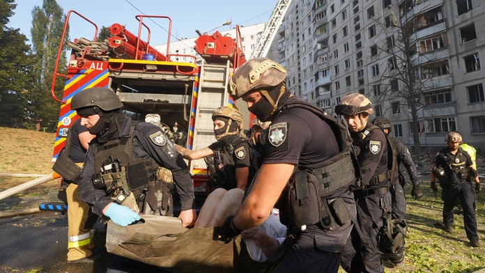 Príslušníci záchranných zložiek odnášajú zranenú osobu po ruskom leteckom útoku na Charkov.