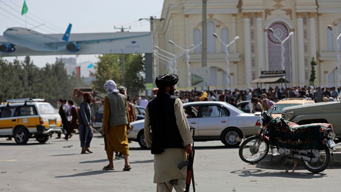 Bojovníci islamistického hnutia Taliban hliadkujú pred letiskom v Kábule.