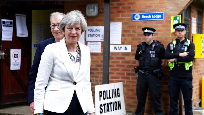 Britská premiérka Theresa Mayová a jej manžel Philip odchádzajú z volebnej miestnosti.