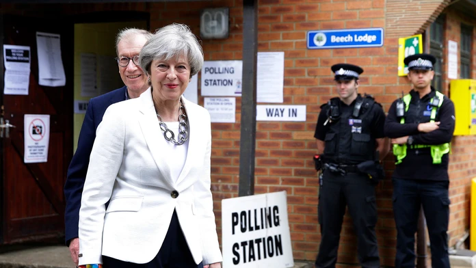 Britská premiérka Theresa Mayová a jej manžel Philip odchádzajú z volebnej miestnosti.
