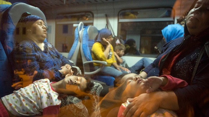 Utečenci spia vo vlaku.