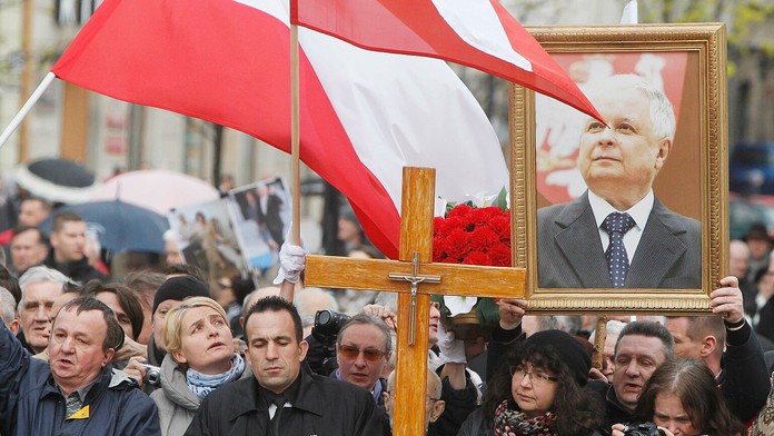 Ľudia držia portrét bývalého poľského prezidenta Lecha Kaczinského.
