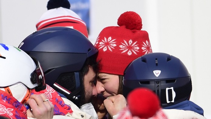 Uprostred slovenská lyžiarka Petra Vlhová oslavuje v cieli s bratom Borisom Vlhom zlato v slalome na ZOH 2022.