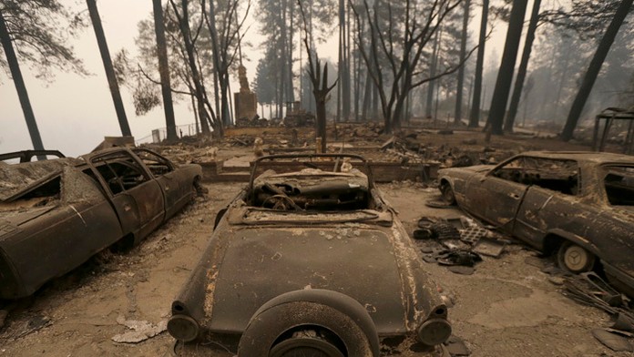 Zhorené automobily pri zhorenom dome v meste Paradise v Kalifornii.