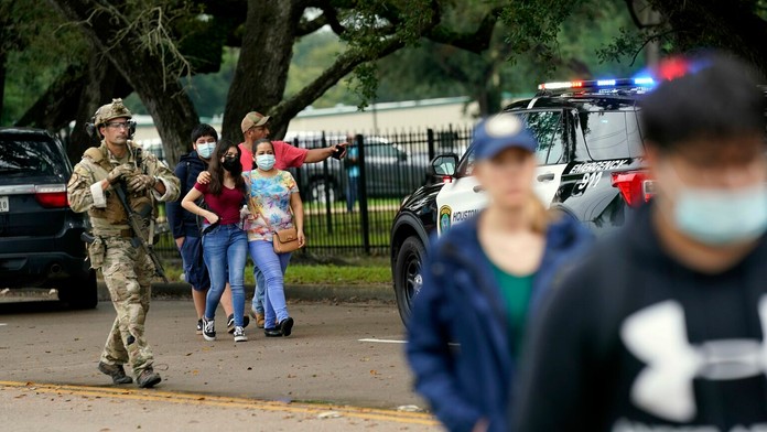 Ľudia kráčajú po streľbe okolo školy YES Prep Southwest Secondary