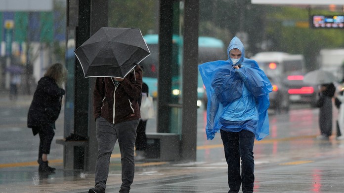 Ľudia kráčajú v daždi