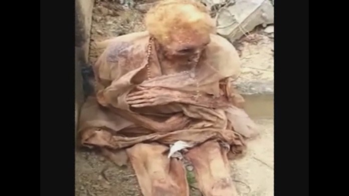 Pochovaná babička sedela vedľa hrobu.