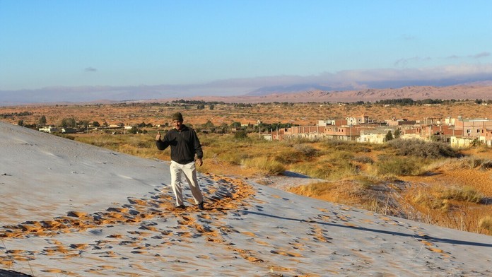 Alžírčan si užíva sneh, ktorý napadol na Sahare.