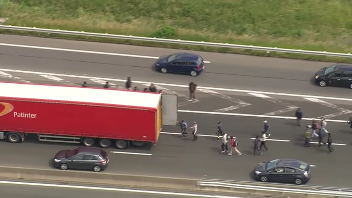 Imigranti sa snažia dostať do kamióna.