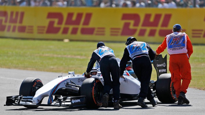 Traťoví komisári odtláčajú monopost testovacej jazdkyne tímu Williams Škótky Susie Wolffovej (4. júla 2014).