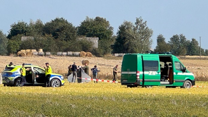 Policajti a príslušníci vojenskej polície zabezpečujú časť úlomkov jedného z dronov, ktoré narušili vzdušný priestor Poľska.