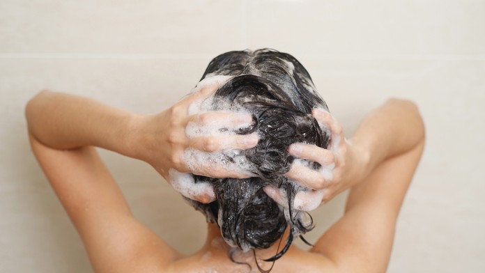 Žena s našampónovanými vlasmi.