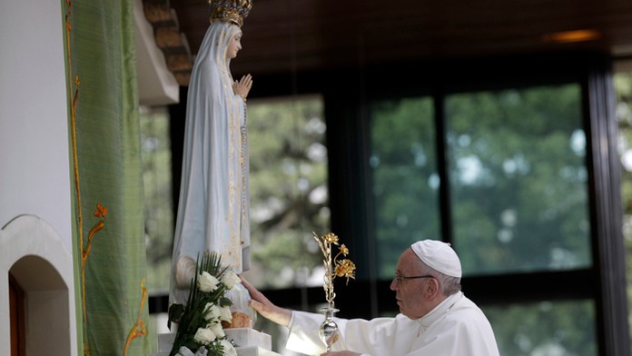 Pápež František sa dotýka sochy Panny Márie v svätyni na mieste jej zjavení v portugalskej Fátime.