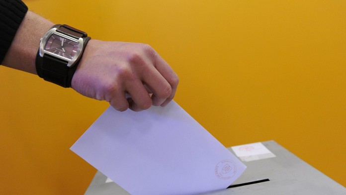 Volič vhadzuje hlasovací lístok do volebnej urny