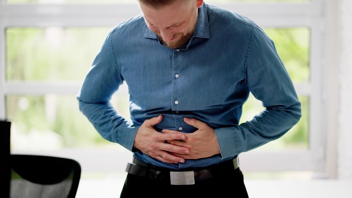 Muž sa drží za brucho 