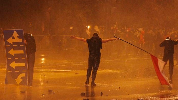 Zásahové jednotky poľskej polície striekajú vodnými delami proti radikálom počas osláv 96. výročia nezávislosti Poľska.