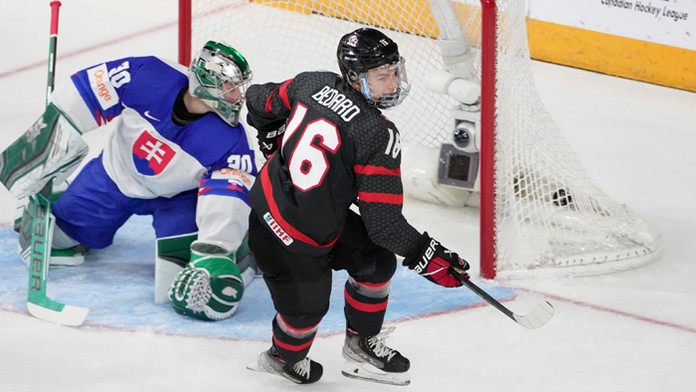 Kanaďan Connor Bedard (vpravo) reaguje po strelení gólu slovenskému brankárovi Jánovi Korecovi (vľavo).