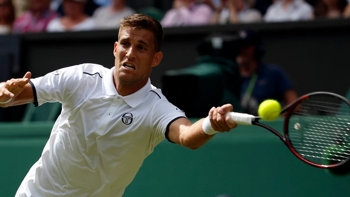 Slovenský tenista Martin Kližan odvracia loptičku Srbovi Novakovi Djokovičovi v 1. kole na turnaji vo Wimbledone.