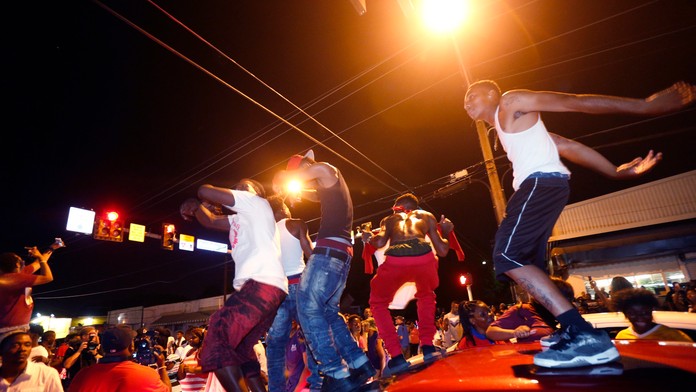 Demonštranti stoja na autách počas demonštrácie v americkom meste Baton Rouge.