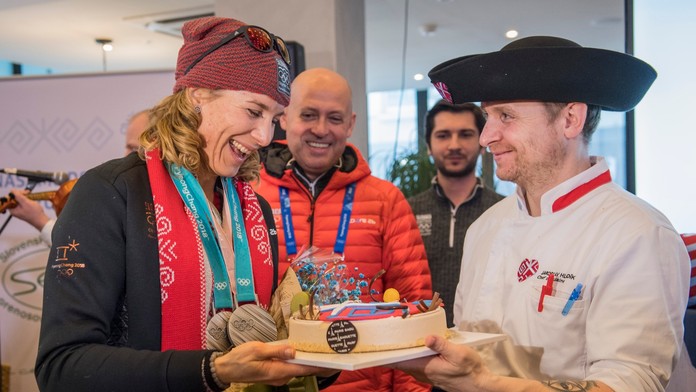 Anastasia Kuzminová si preberá tortu, uprostred prezident SOV Anton Siekel v Slovenskom dome počas ZOH v Pjongčangu.