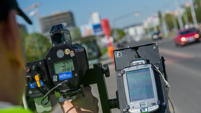 Na snímke príslušník dopravnej polície meria rýchlosť vozidiel (ilustračná snímka)