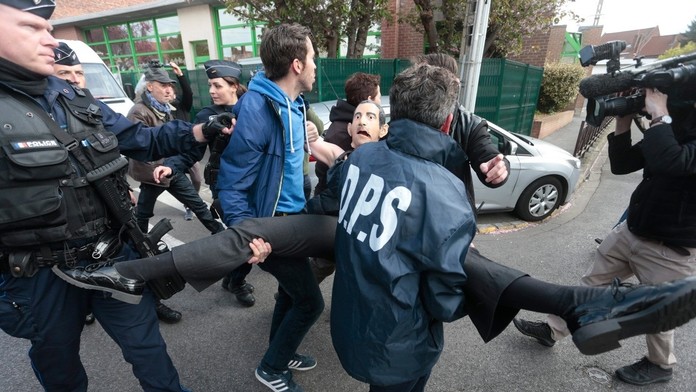 Aktivistku hnutia Femen odvádzajú policajti.