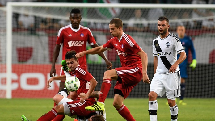 Trenčania Denis Jančo (dole), Christopher Udeh (vľavo vzadu), James Lawrence (druhý sprava) a hráči Varšavy Nemanja Nikolič (vpr