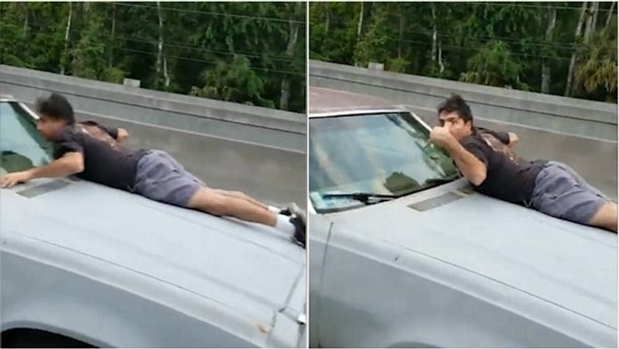 Muž na kapote svojho auto, ktoré mu chceli ukradnúť