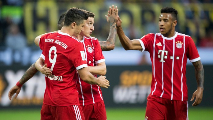 Hráč Bayernu Mníchov Robert Lewandowski (vľavo) s teší z gólu so spoluhráčmi Sebastianom Rudym (uprostred) a Corentim Tolissom 