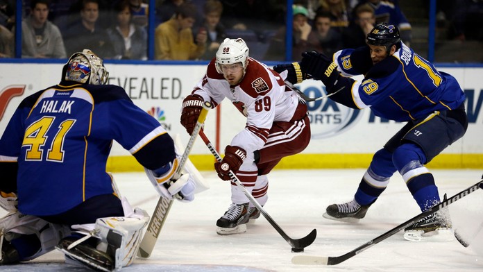 Hokejista Phoenixu Coyotes Mikkel Boedker (uprostred) z Dánska, brankár St. Louis Blues Slovák Jaroslav Halák (vľavo) a jeho spo