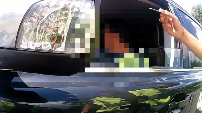 Policajt kontroluje vodičovi doklady