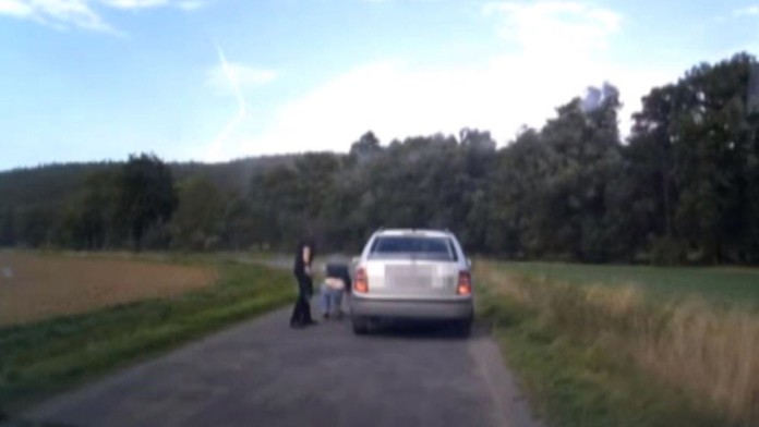 Hádajúci sa muži na poľnej ceste.