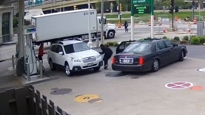 Zlodej otvára dvere na aute nič netušiacej ženy.