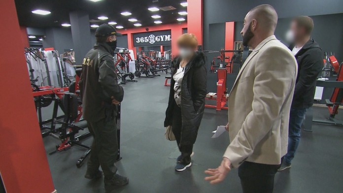 Majiteľ fitnescentra (vpravo) v debate s políciou a hygienikmi.