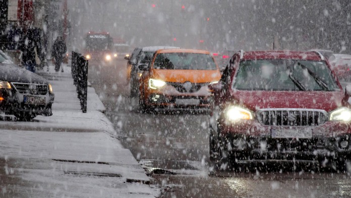 Na snímke autá jazdia počas hustého sneženia.