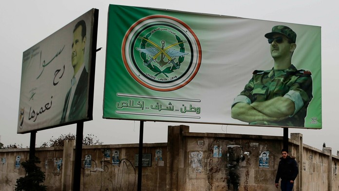 Sýrčan kráča okolo bilbordov s portrétom sýrskeho prezidenta Bašara Asada v západnej časti sýrskeho mesta Aleppo.