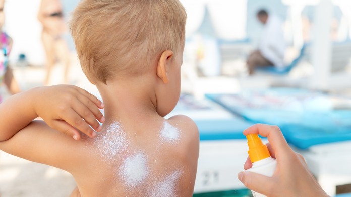 Matka dáva synovi ochranu pred slnkom